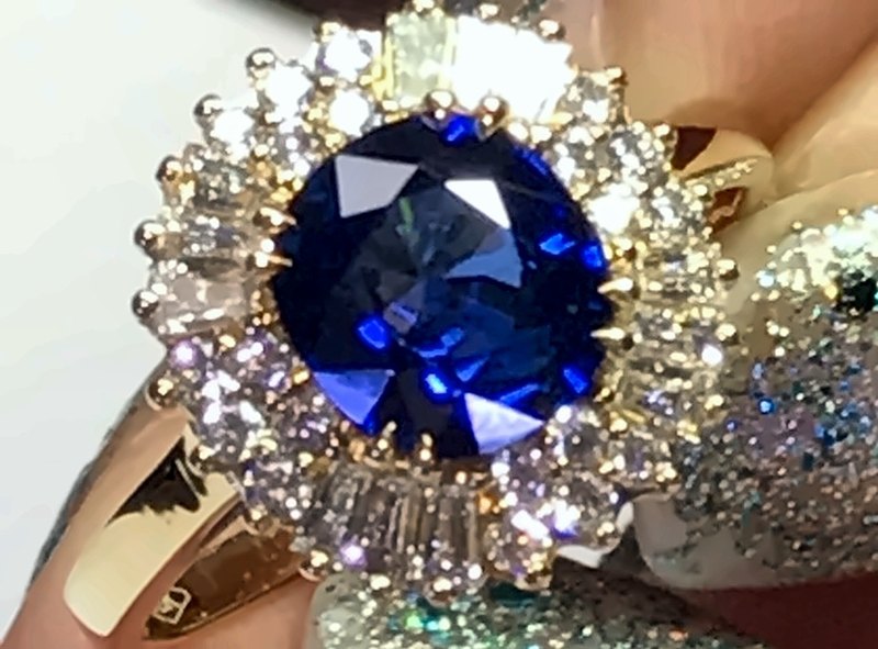 Bague entourage saphir coussin finie, tenue en main