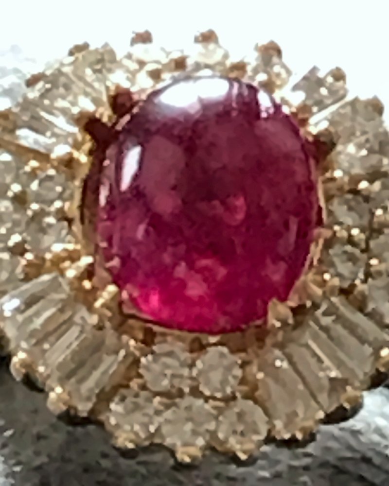 Bague en or jaune, rubis cabochon, entourage de diamants baguettes et ronds