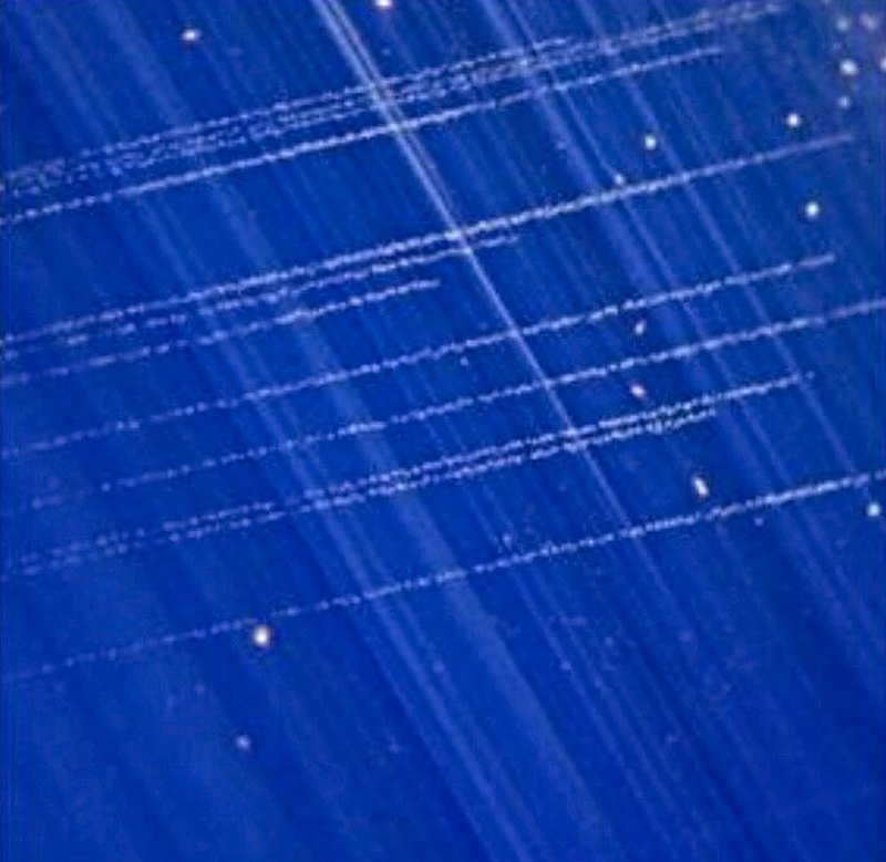 Fines aiguilles de rutile (soie) dans un saphir, au microscope